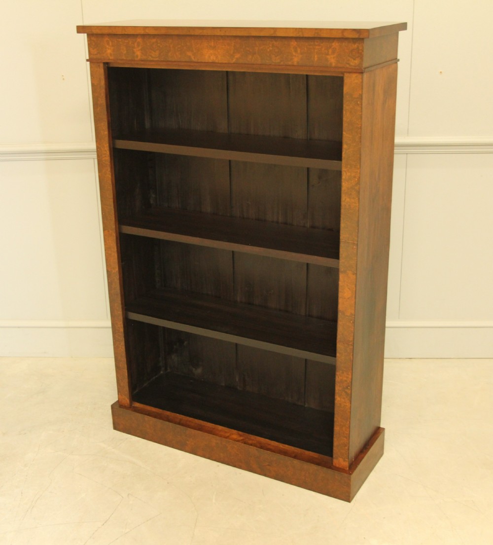 A Victorian open bookcase featuring faux burr walnut outer framing, dark interior shelves, and a solid plinth base. View III