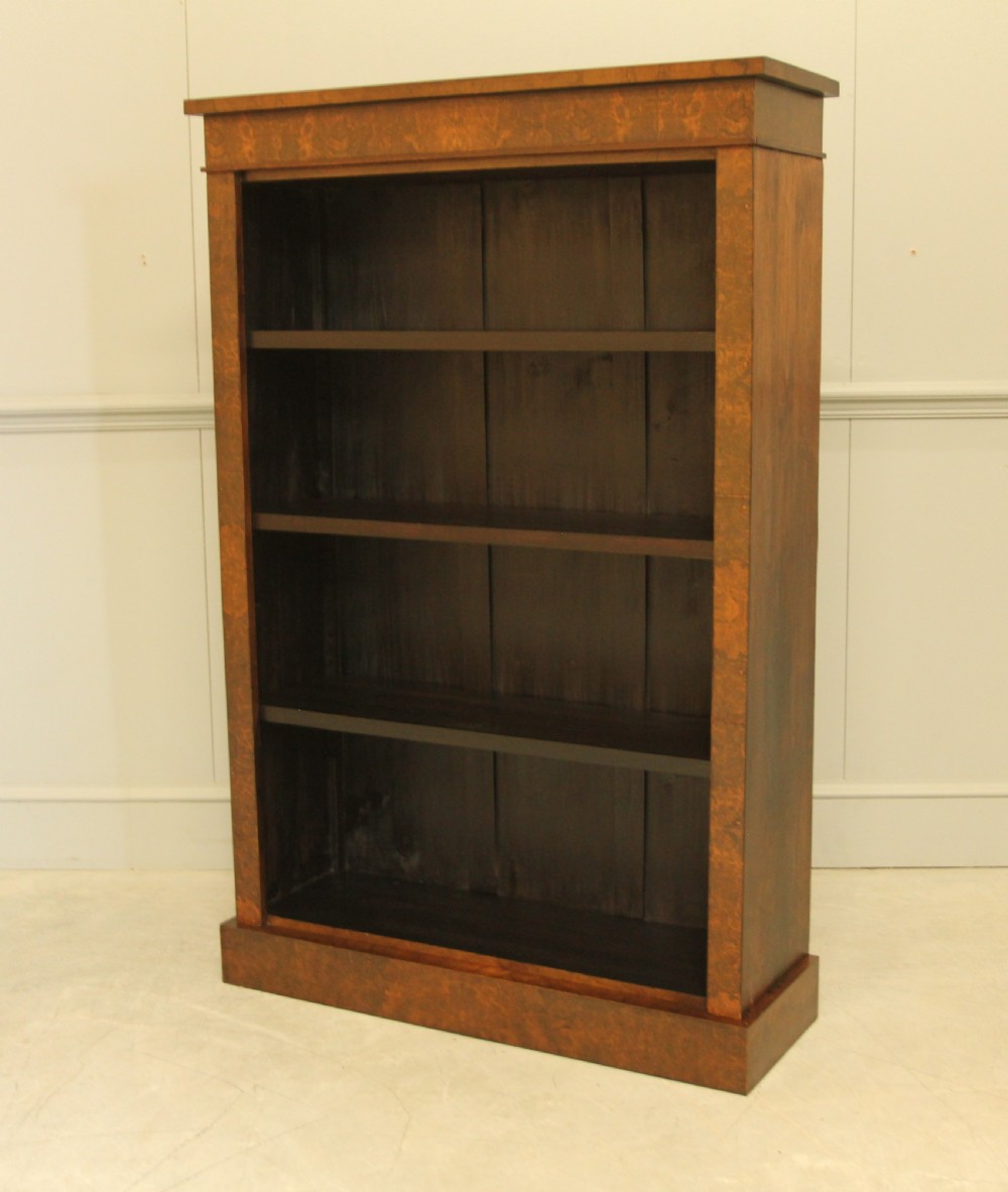 A Victorian open bookcase featuring faux burr walnut outer framing, dark interior shelves, and a solid plinth base. View IV