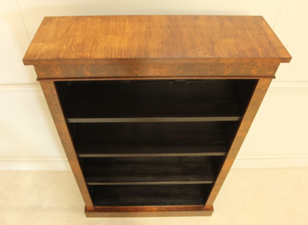 A Victorian open bookcase featuring faux burr walnut outer framing, dark interior shelves, and a solid plinth base. View IX