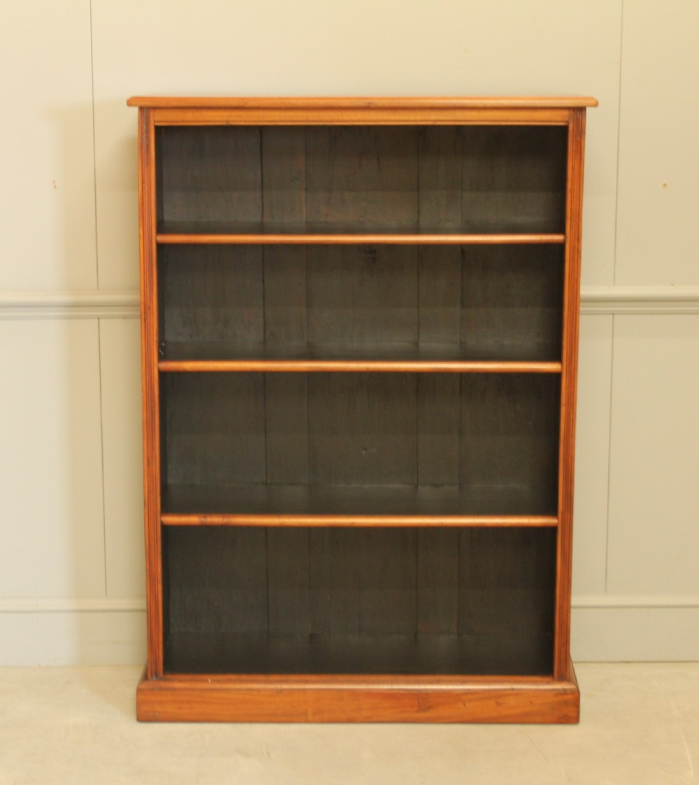 A tall open-front mahogany bookcase featuring four wide shelves, a moulded top cornice, dark backboards, and a solid plinth base. View II
