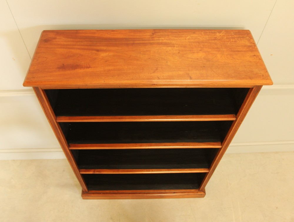 A tall open-front mahogany bookcase featuring four wide shelves, a moulded top cornice, dark backboards, and a solid plinth base. View VIII