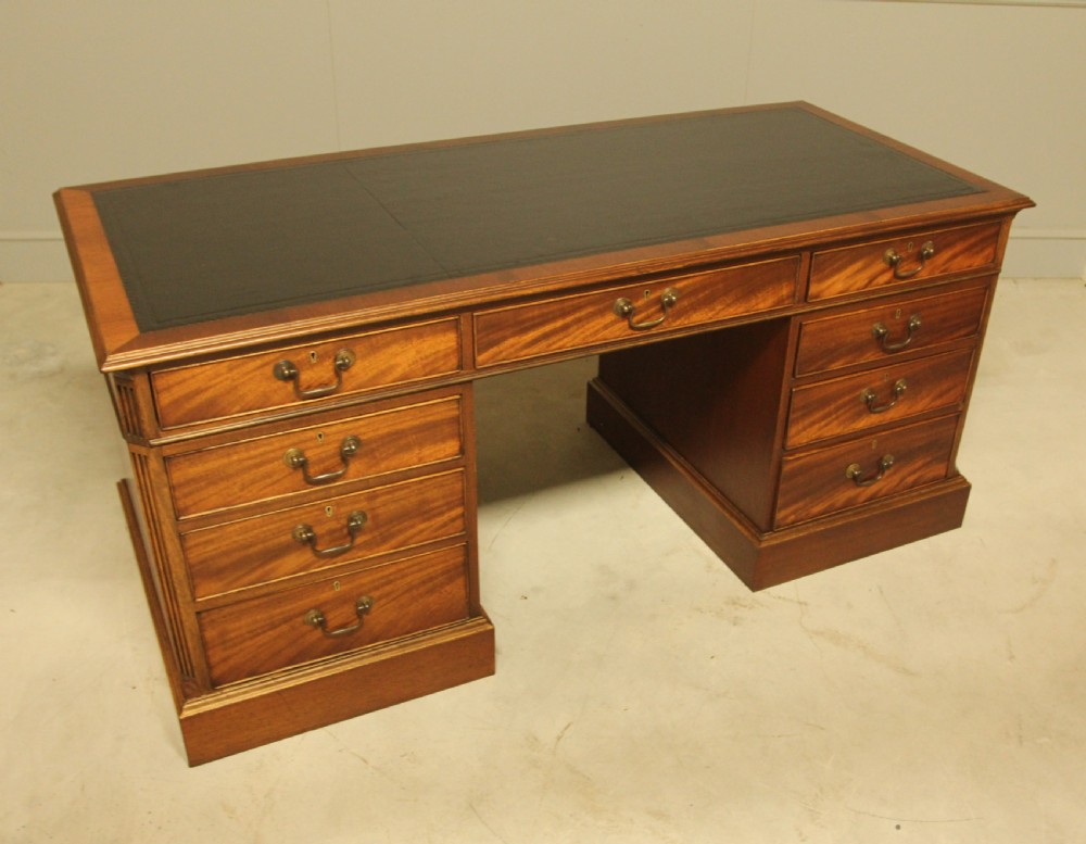 An early 20th-century twin pedestal desk crafted from curl mahogany with a dark leather inset top and brass swan-neck handles. View III