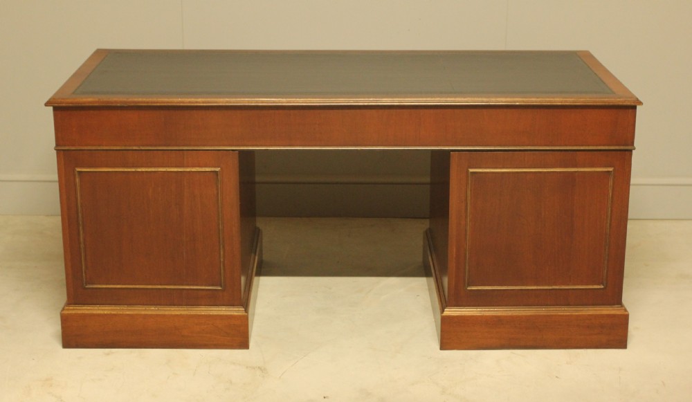 An early 20th-century twin pedestal desk crafted from curl mahogany with a dark leather inset top and brass swan-neck handles. View XI