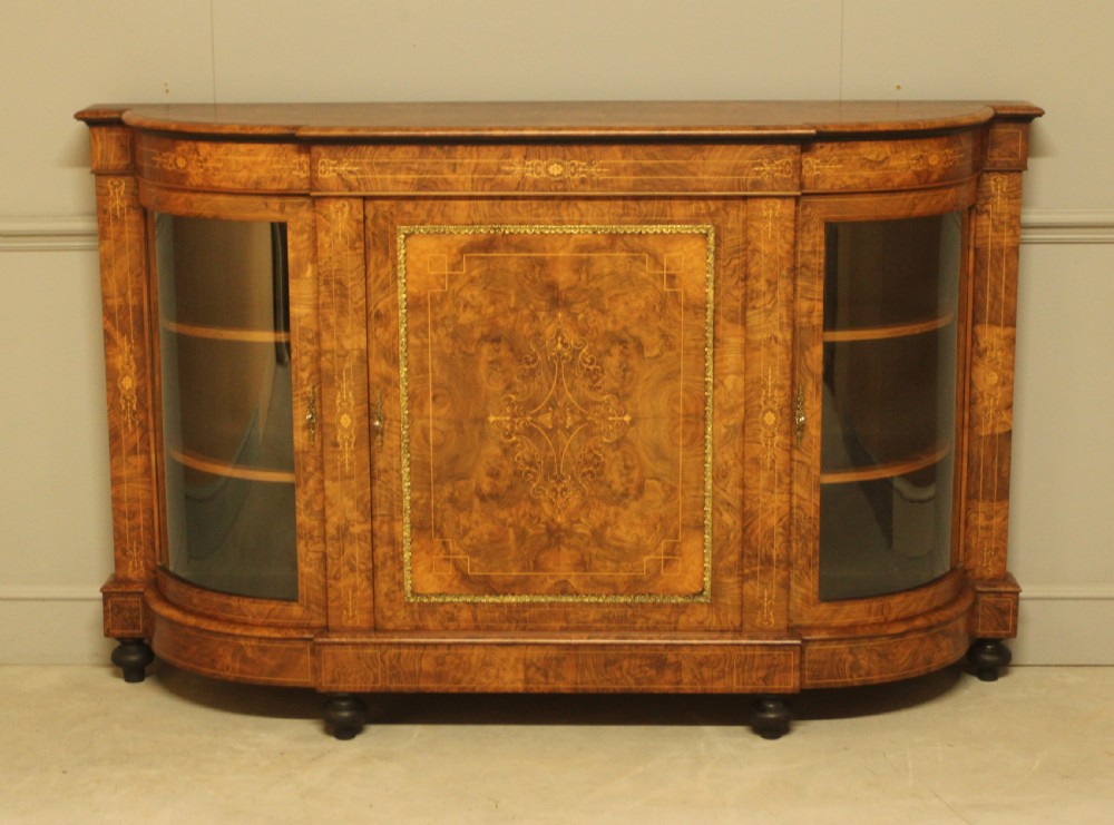 A Victorian burr walnut credenza featuring a central inlaid panel door flanked by two curved glass display doors with brass trim. View II