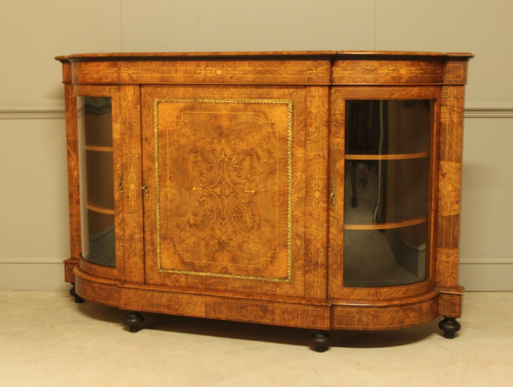 A Victorian burr walnut credenza featuring a central inlaid panel door flanked by two curved glass display doors with brass trim. View V