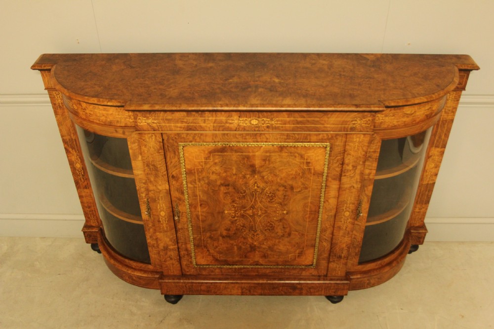 A Victorian burr walnut credenza featuring a central inlaid panel door flanked by two curved glass display doors with brass trim. View VIII