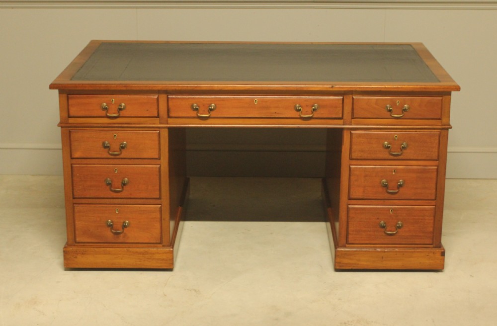 An early 20th-century mahogany pedestal writing desk featuring a dark leather inset top and nine drawers with brass swan-neck handles. View II