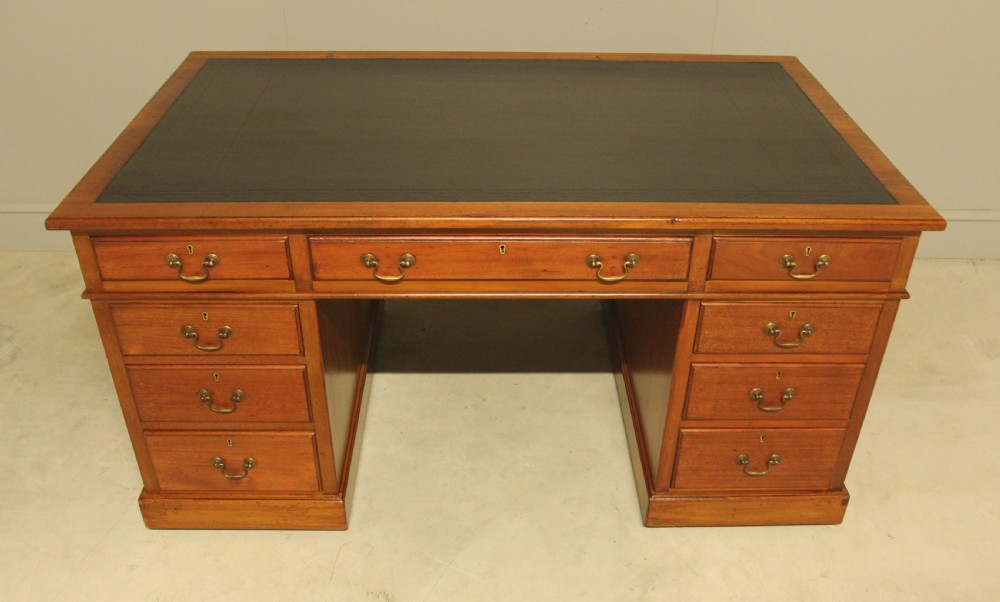 An early 20th-century mahogany pedestal writing desk featuring a dark leather inset top and nine drawers with brass swan-neck handles. View III