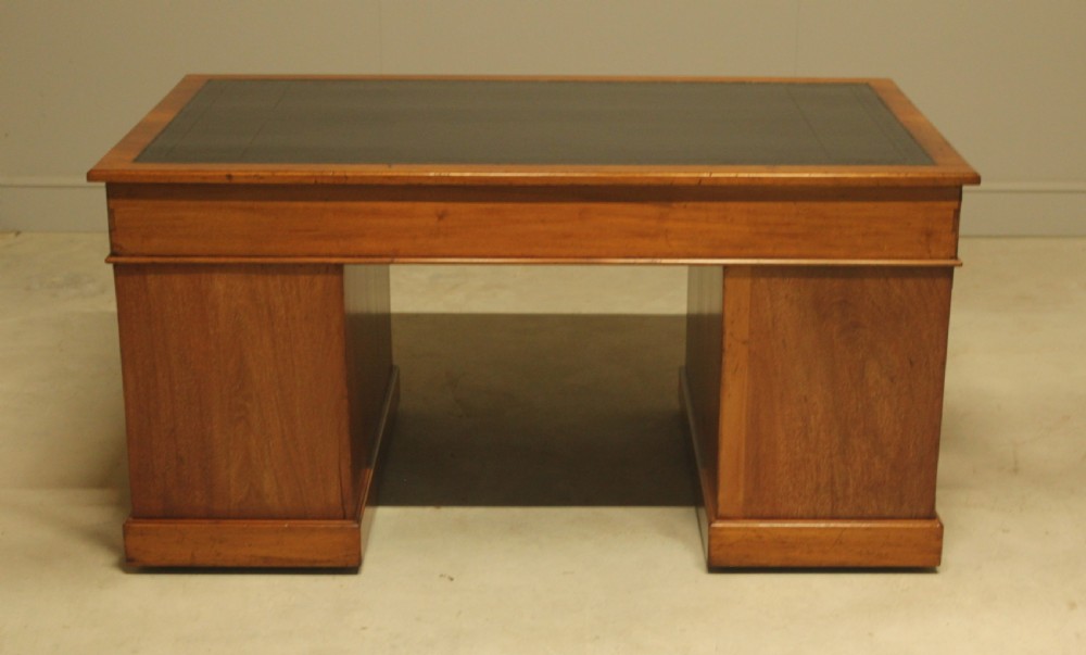 An early 20th-century mahogany pedestal writing desk featuring a dark leather inset top and nine drawers with brass swan-neck handles. View IX