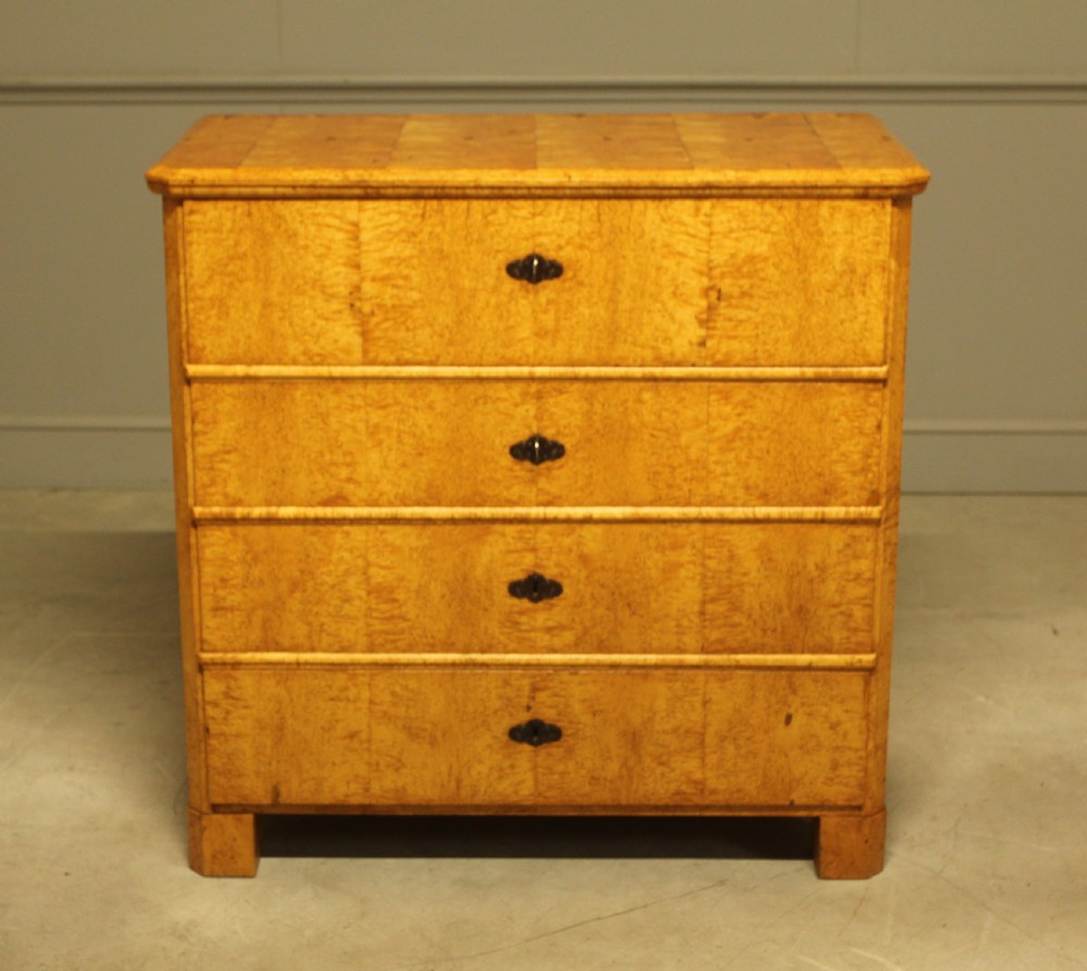 A nineteenth-century Swedish chest of drawers featuring four drawers crafted from light golden masur birch with dark keyhole escutcheons. View II