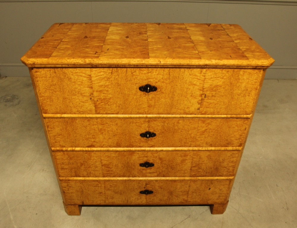 A nineteenth-century Swedish chest of drawers featuring four drawers crafted from light golden masur birch with dark keyhole escutcheons. View III