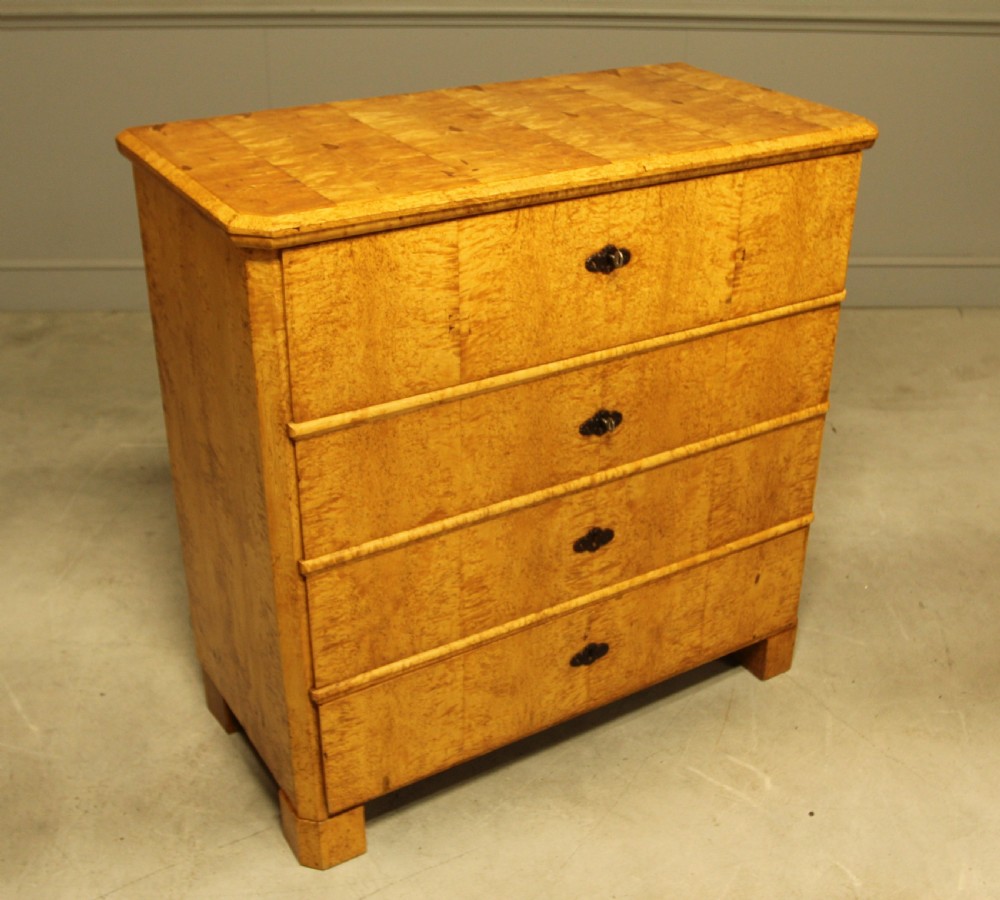 A nineteenth-century Swedish chest of drawers featuring four drawers crafted from light golden masur birch with dark keyhole escutcheons. View IV