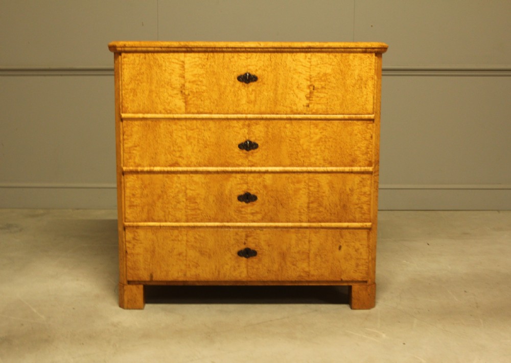 A nineteenth-century Swedish chest of drawers featuring four drawers crafted from light golden masur birch with dark keyhole escutcheons. View VIII