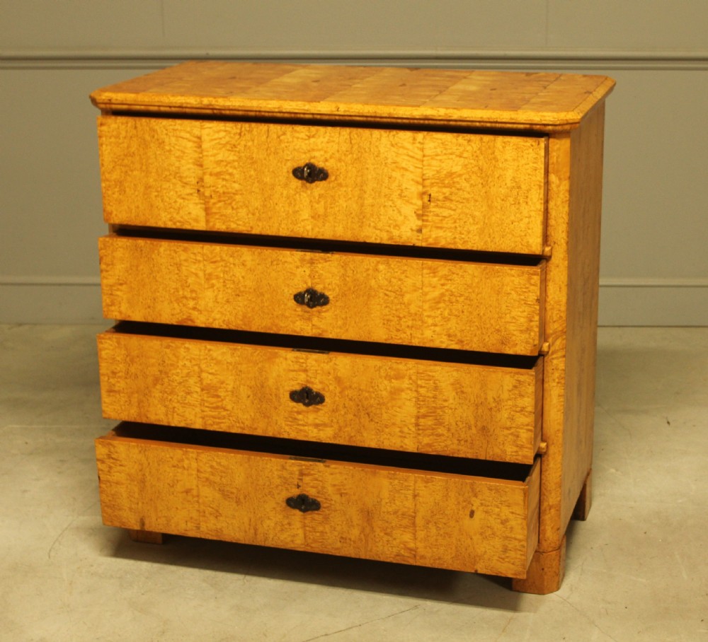 A nineteenth-century Swedish chest of drawers featuring four drawers crafted from light golden masur birch with dark keyhole escutcheons. View IX