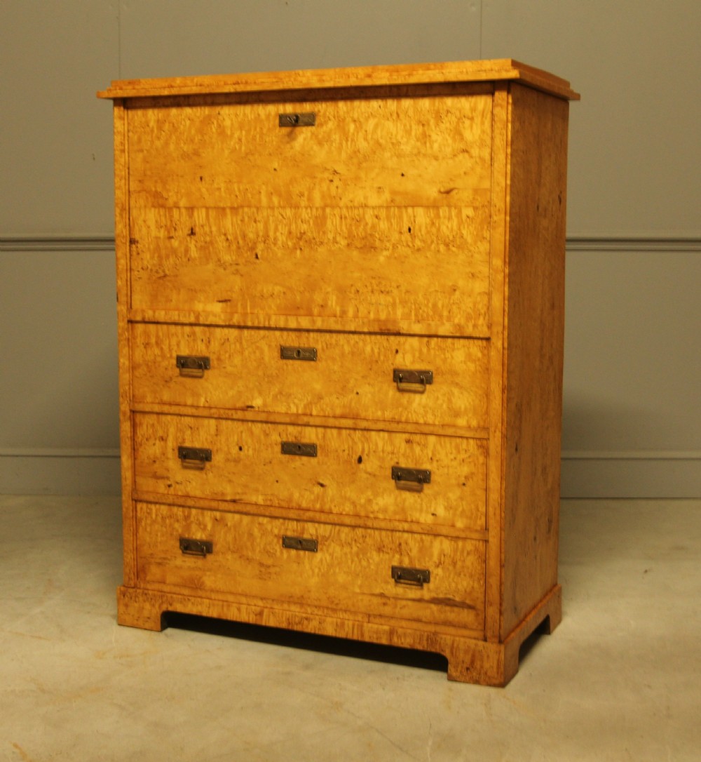 A 19th-century Swedish Masur birch secretaire desk featuring a fall-front top compartment above three wide drawers with brass handles. View VI