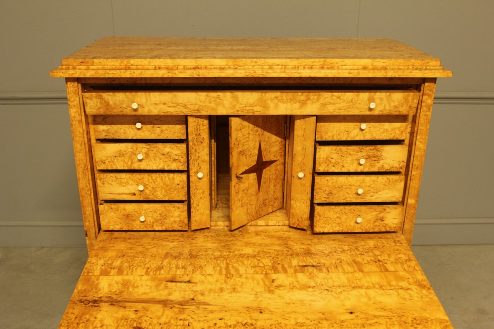 A 19th-century Swedish Masur birch secretaire desk featuring a fall-front top compartment above three wide drawers with brass handles. View XI