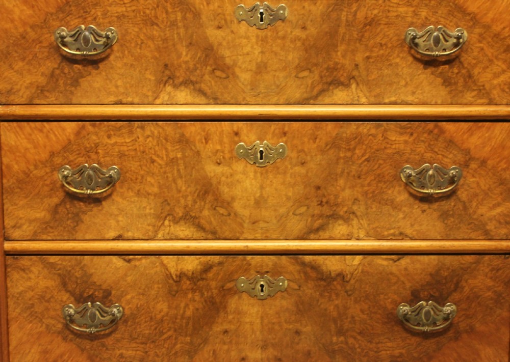 An early 20th-century Swedish chest of drawers featuring three full-width drawers with rich burr walnut veneer, brass bail handles, and keyhole escutcheons. View IX