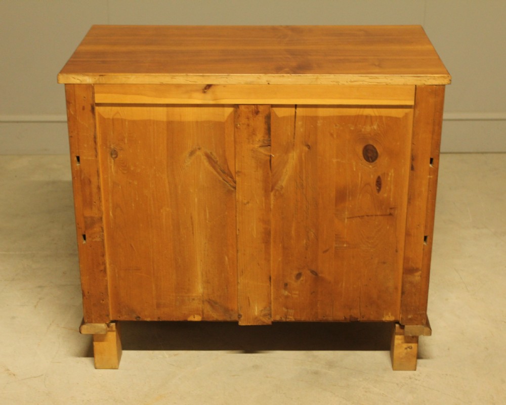 An early 20th-century Swedish chest of drawers featuring three full-width drawers with rich burr walnut veneer, brass bail handles, and keyhole escutcheons. View X