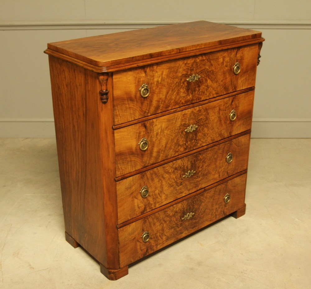 A late nineteenth-century Swedish burr walnut chest of drawers with four full-width drawers and brass handles. View V