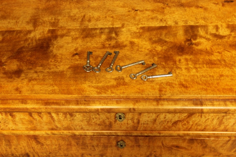 An early twentieth-century Swedish tall chest of drawers crafted in figured golden satin birch with six graduated drawers and brass escutcheons. View IX