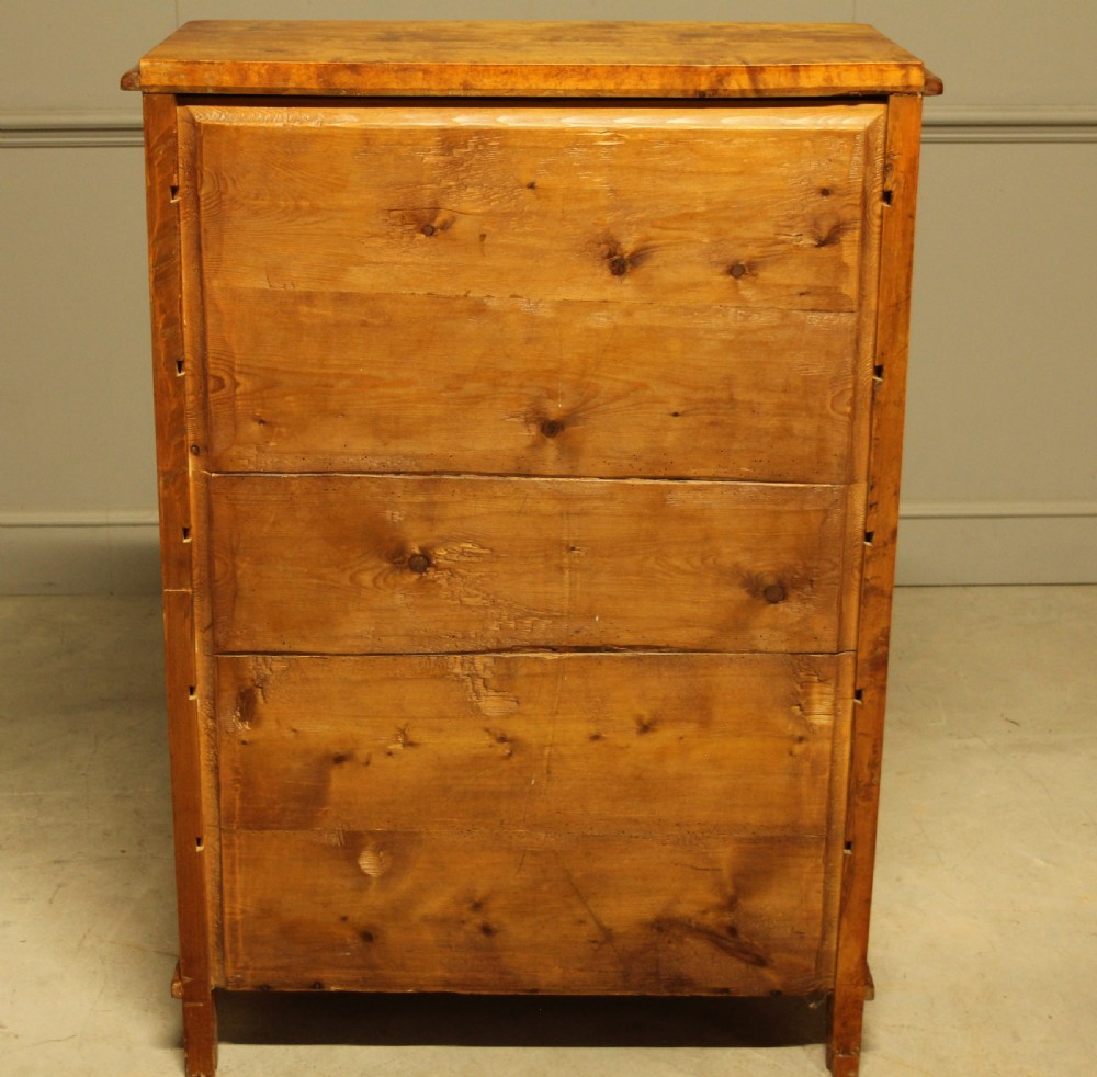 An early twentieth-century Swedish tall chest of drawers crafted in figured golden satin birch with six graduated drawers and brass escutcheons. View X