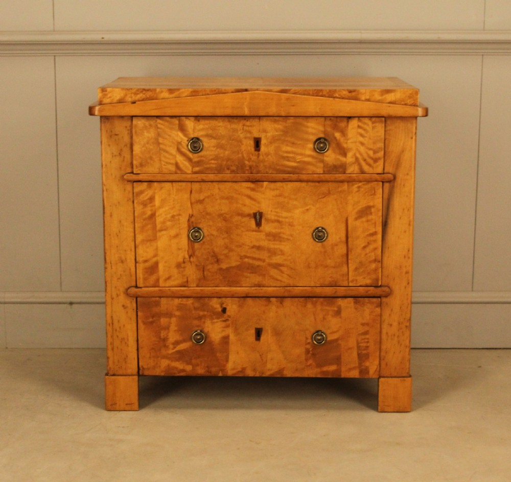 A 19th-century Swedish satin birch chest of drawers featuring three drawers with brass ring pull handles and a visible flame wood grain pattern.