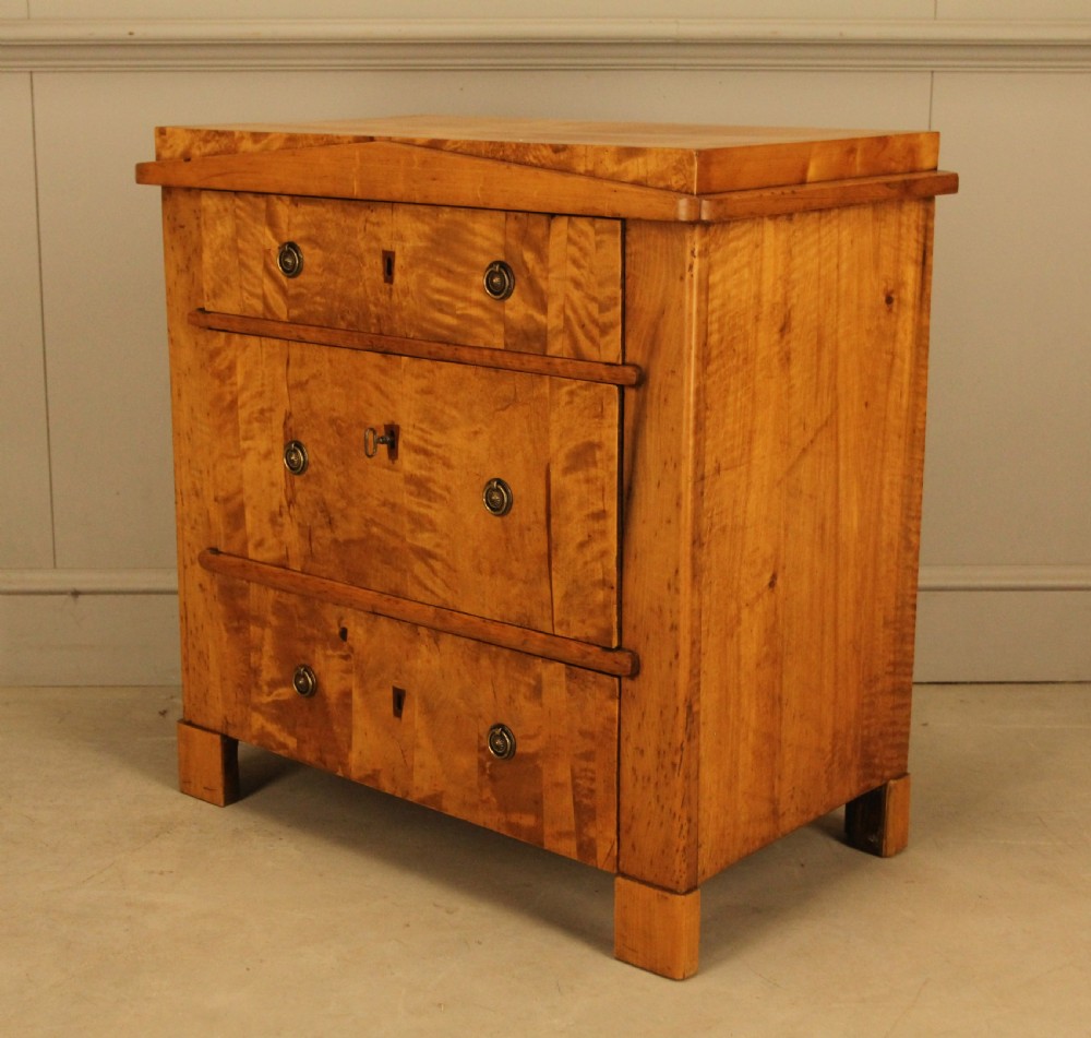 A 19th-century Swedish satin birch chest of drawers featuring three drawers with brass ring pull handles and a visible flame wood grain pattern. View V