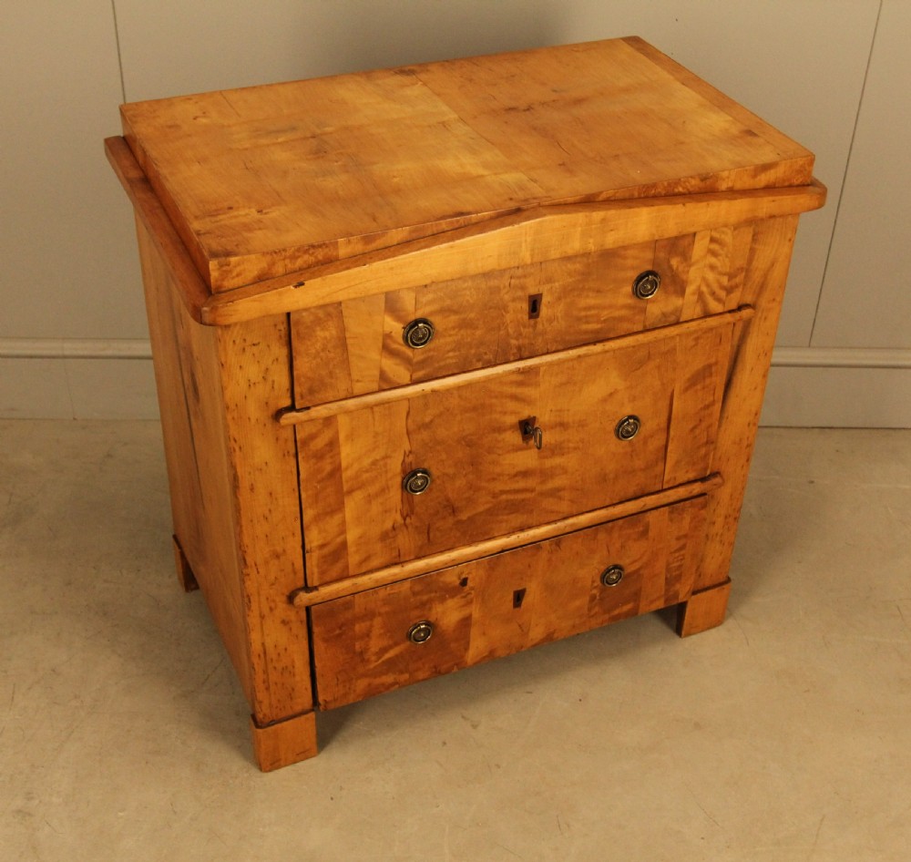 A 19th-century Swedish satin birch chest of drawers featuring three drawers with brass ring pull handles and a visible flame wood grain pattern. View VI