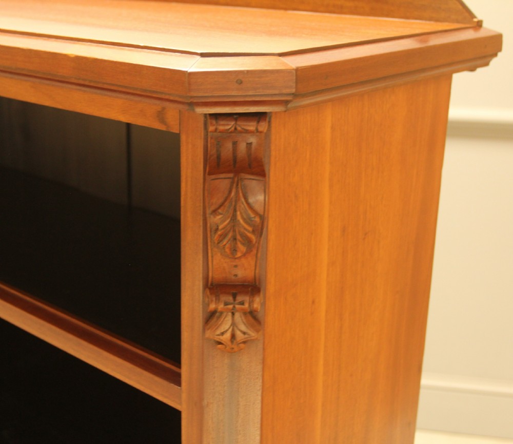 A Victorian warm brown mahogany open bookcase with two sections of shelves, carved corbel details, and a plinth base. View IV