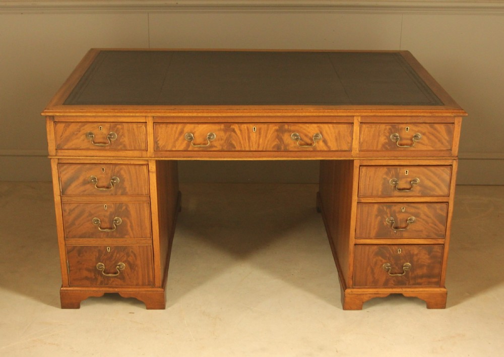 A Victorian mahogany partners desk featuring a brown leather writing inset, twin pedestals with nine drawers, and brass swan-neck handles. View II