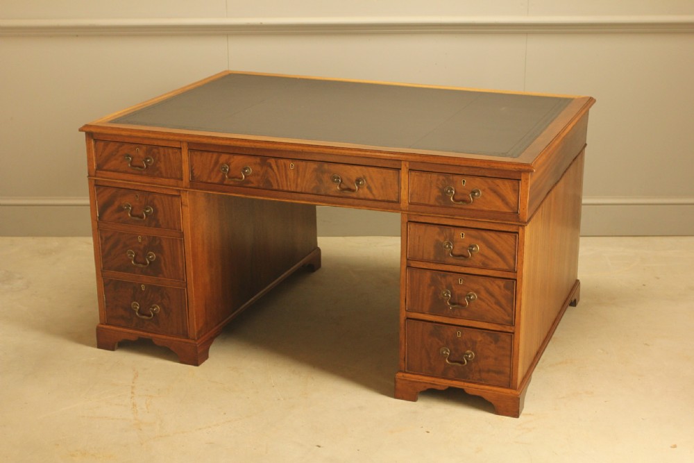 A Victorian mahogany partners desk featuring a brown leather writing inset, twin pedestals with nine drawers, and brass swan-neck handles. View IV