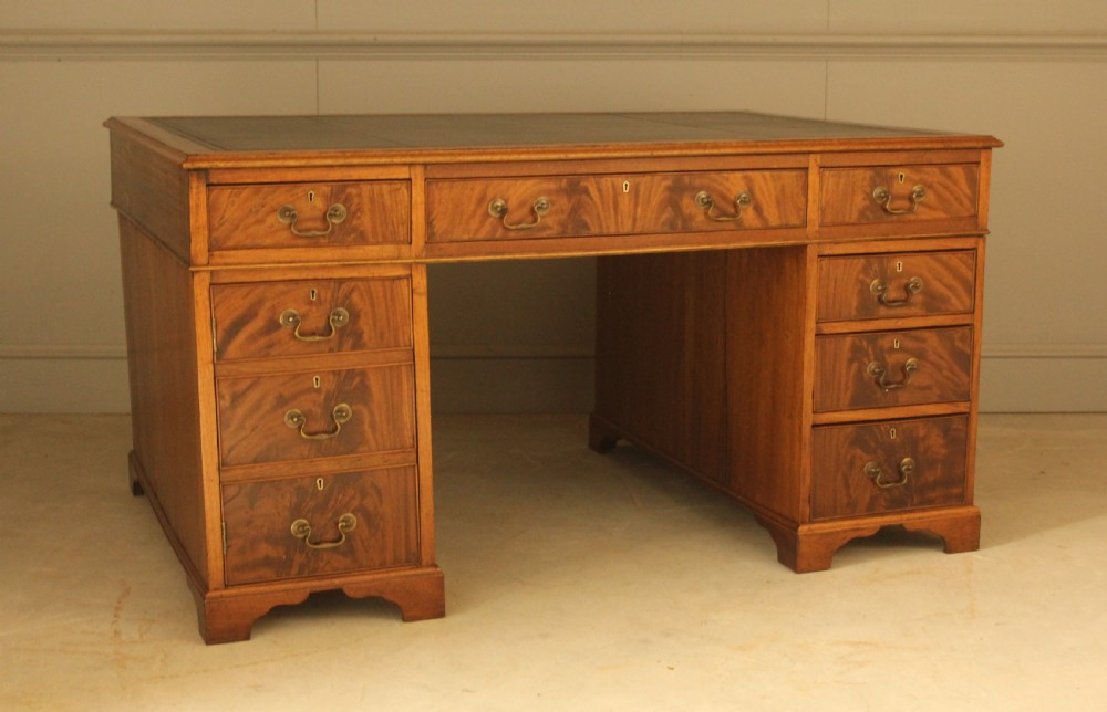 A Victorian mahogany partners desk featuring a brown leather writing inset, twin pedestals with nine drawers, and brass swan-neck handles. View VII