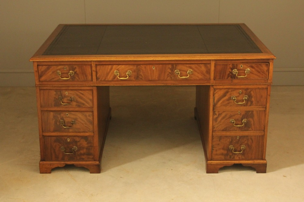 A Victorian mahogany partners desk featuring a brown leather writing inset, twin pedestals with nine drawers, and brass swan-neck handles. View IX