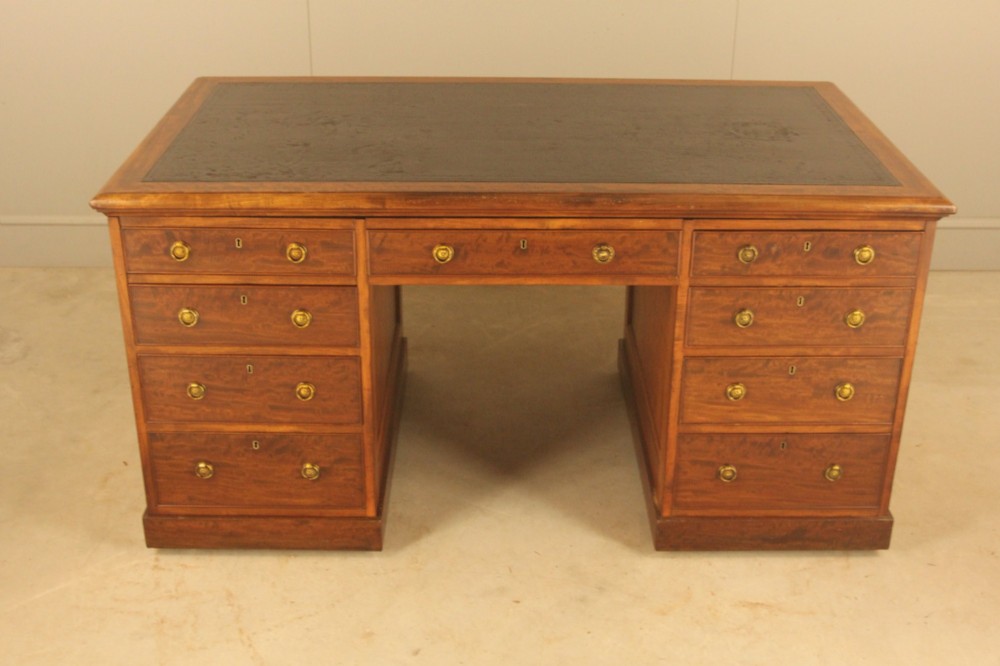 A 19th-century mahogany partners desk featuring a dark leather writing inset top, nine drawers on the front with brass ring handles, and twin pedestal bases. View II