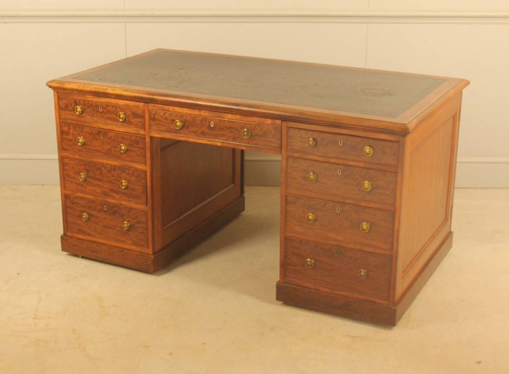 A 19th-century mahogany partners desk featuring a dark leather writing inset top, nine drawers on the front with brass ring handles, and twin pedestal bases. View VI