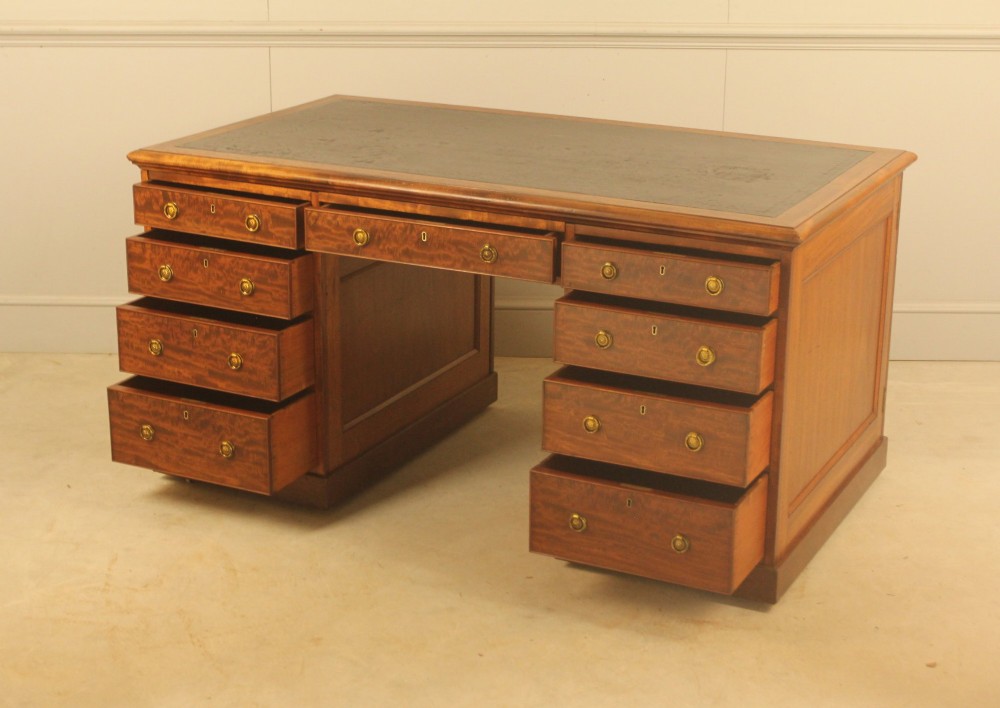 A 19th-century mahogany partners desk featuring a dark leather writing inset top, nine drawers on the front with brass ring handles, and twin pedestal bases. View VIII