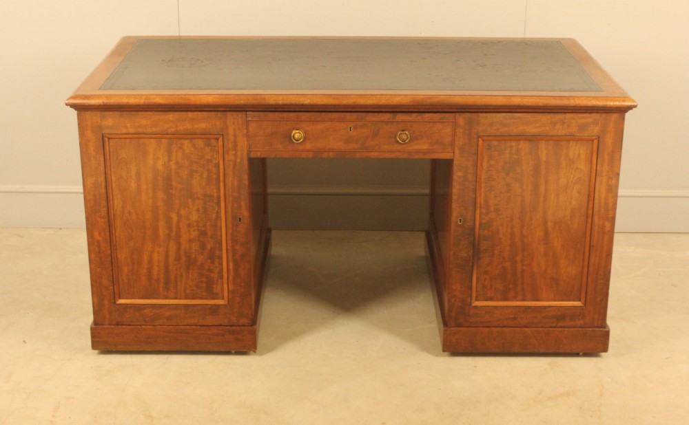 A 19th-century mahogany partners desk featuring a dark leather writing inset top, nine drawers on the front with brass ring handles, and twin pedestal bases. View X