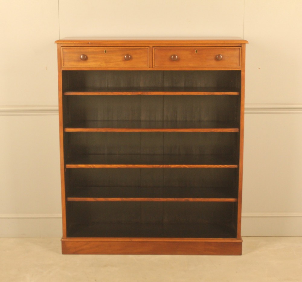 A tall 19th-century mahogany open bookcase featuring two upper frieze drawers with turned wooden knobs above five open shelves supported by a solid plinth base.