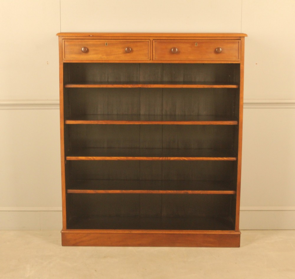 A tall 19th-century mahogany open bookcase featuring two upper frieze drawers with turned wooden knobs above five open shelves supported by a solid plinth base. View IV