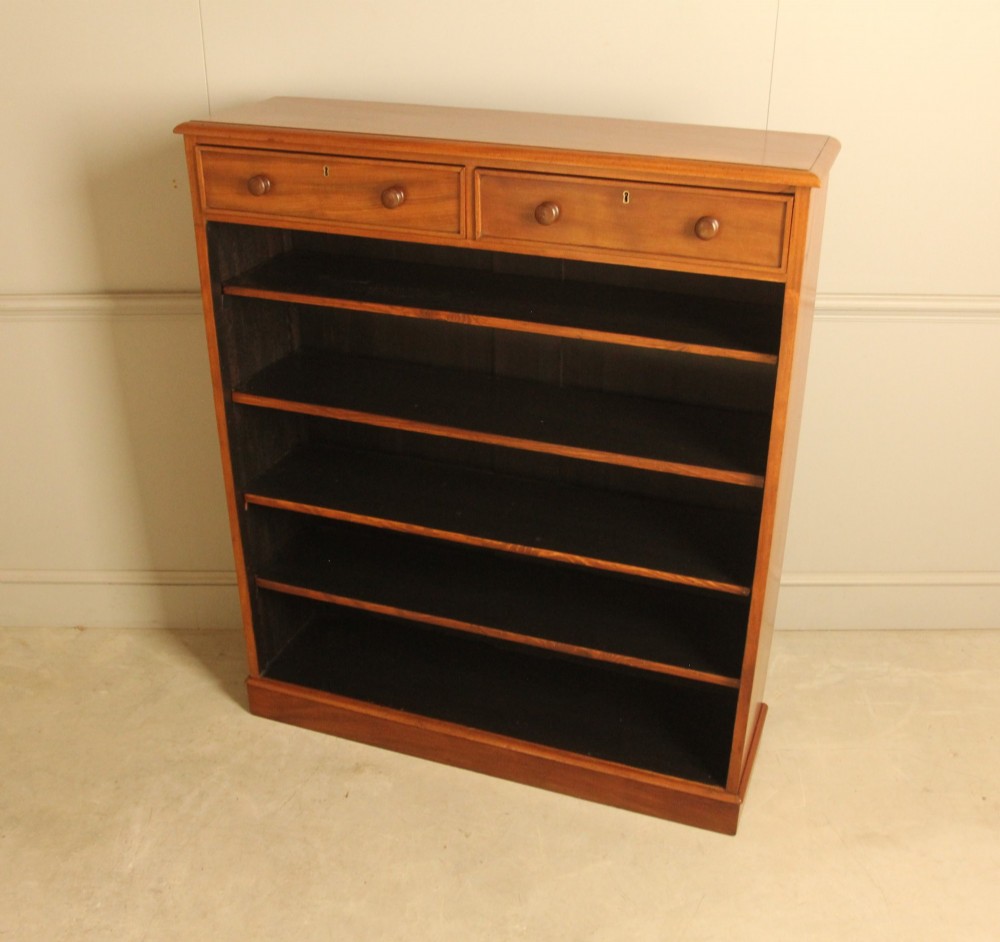 A tall 19th-century mahogany open bookcase featuring two upper frieze drawers with turned wooden knobs above five open shelves supported by a solid plinth base. View VI