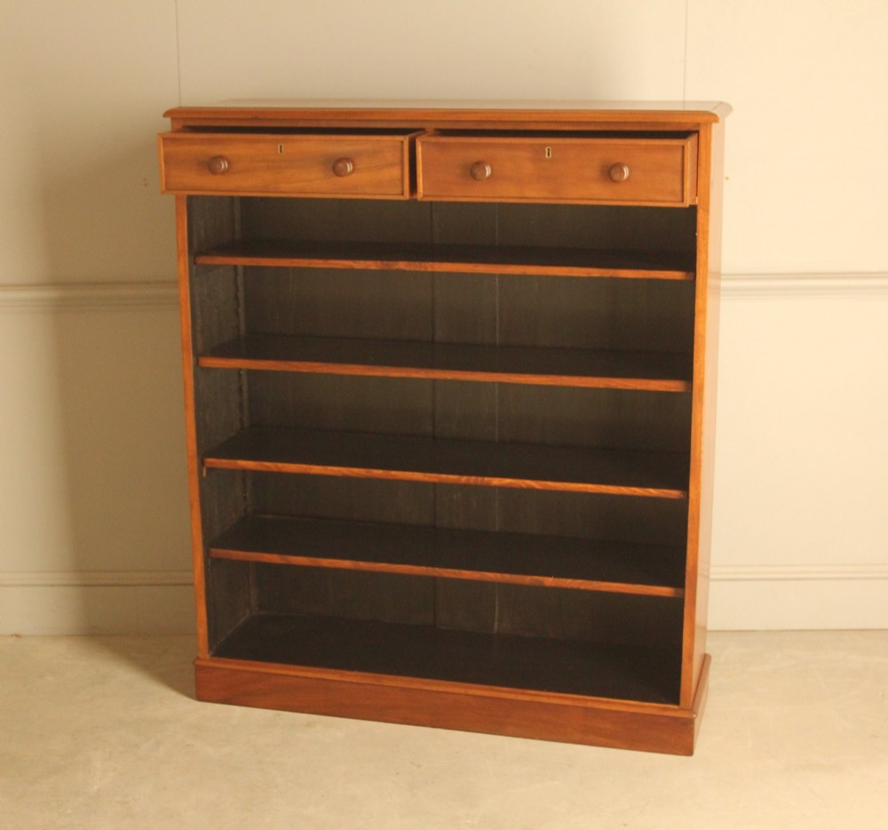 A tall 19th-century mahogany open bookcase featuring two upper frieze drawers with turned wooden knobs above five open shelves supported by a solid plinth base. View VII