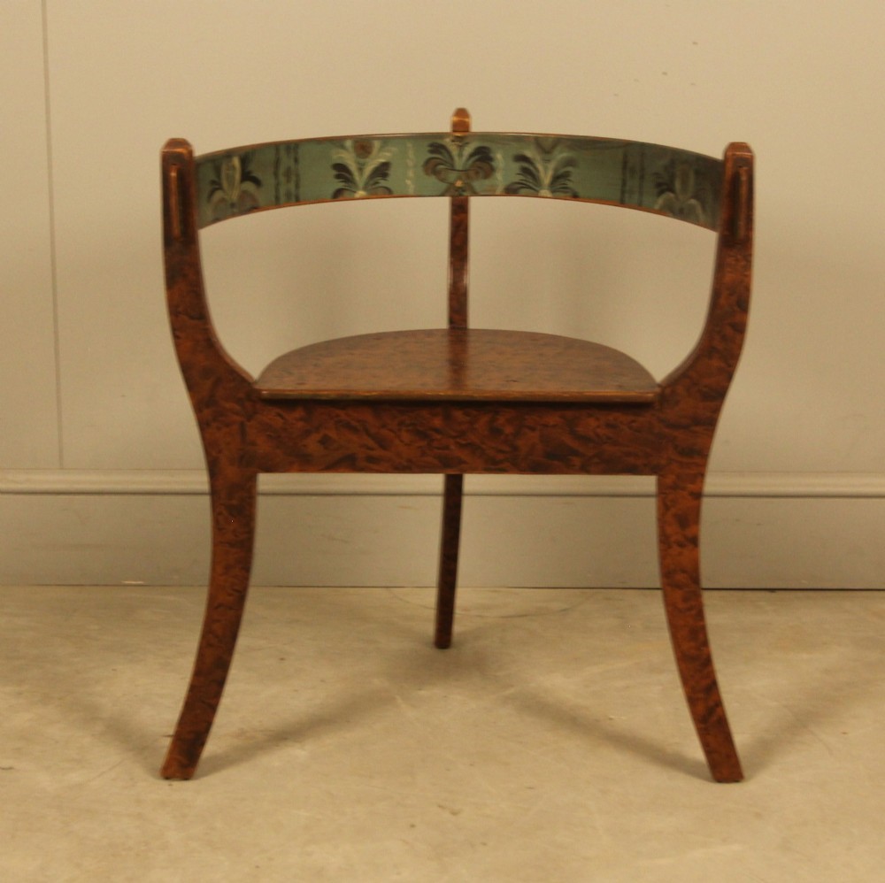 An early 20th-century Norwegian wooden chair with a curved backrest decorated with hand-painted green floral motifs and a faux-grained finish. View V