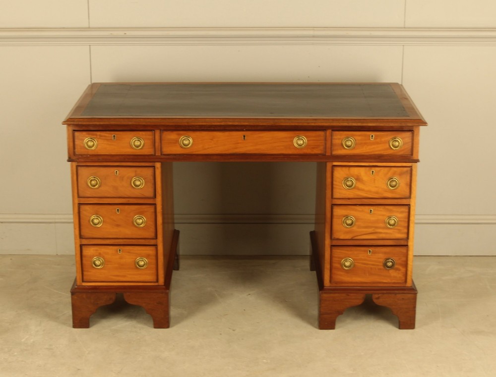 Victorian mahogany pedestal writing desk featuring nine drawers with brass ring pulls and bracket feet. View II