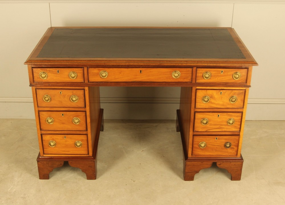 Victorian mahogany pedestal writing desk featuring nine drawers with brass ring pulls and bracket feet. View III