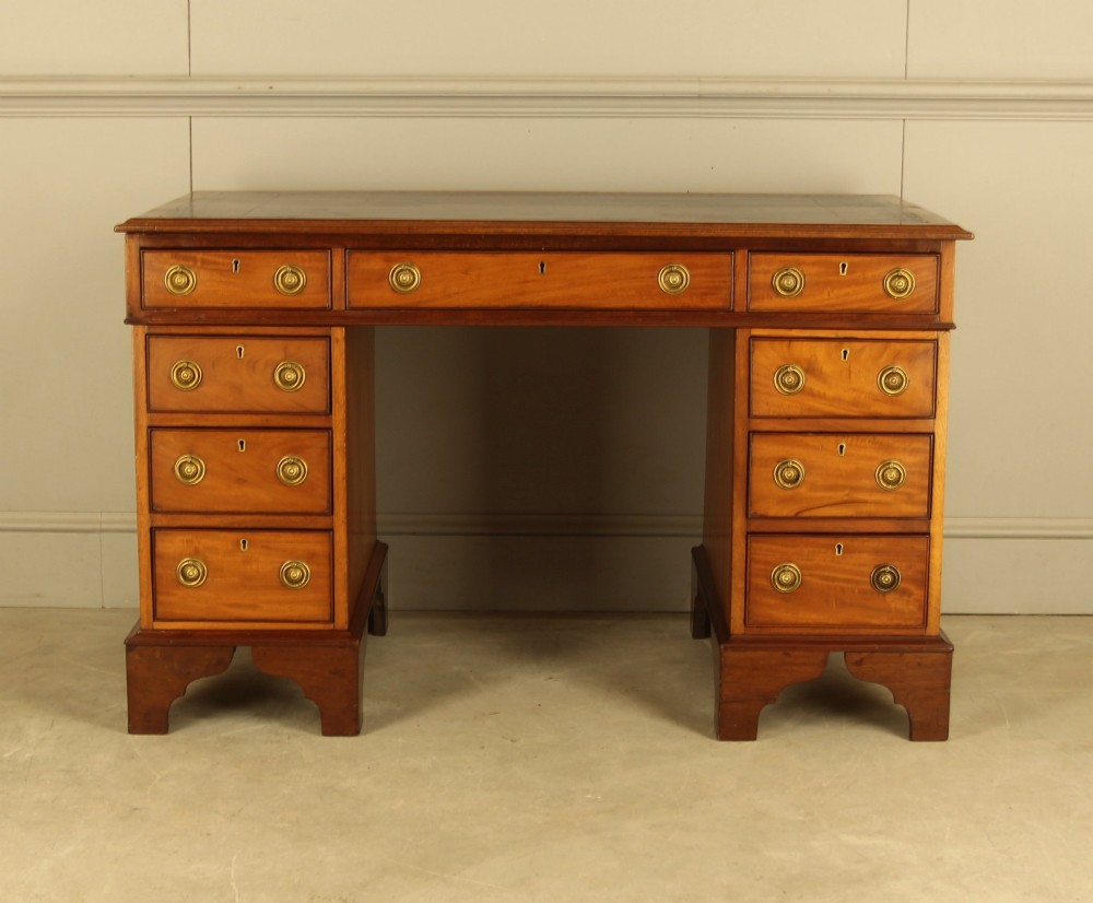 Victorian mahogany pedestal writing desk featuring nine drawers with brass ring pulls and bracket feet. View IV