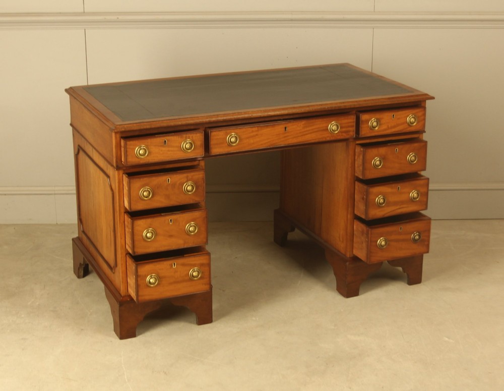 Victorian mahogany pedestal writing desk featuring nine drawers with brass ring pulls and bracket feet. View VI