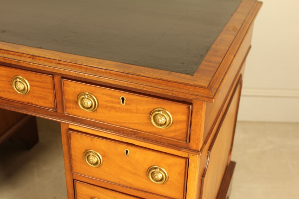 Victorian mahogany pedestal writing desk featuring nine drawers with brass ring pulls and bracket feet. View IX