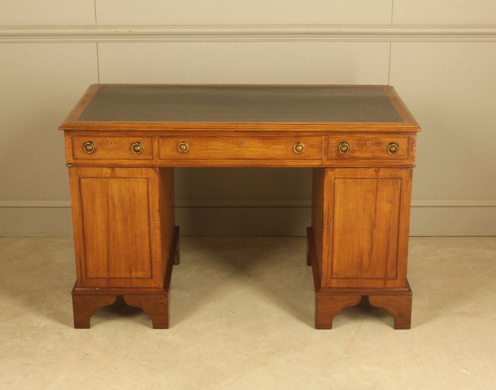 Victorian mahogany pedestal writing desk featuring nine drawers with brass ring pulls and bracket feet. View X