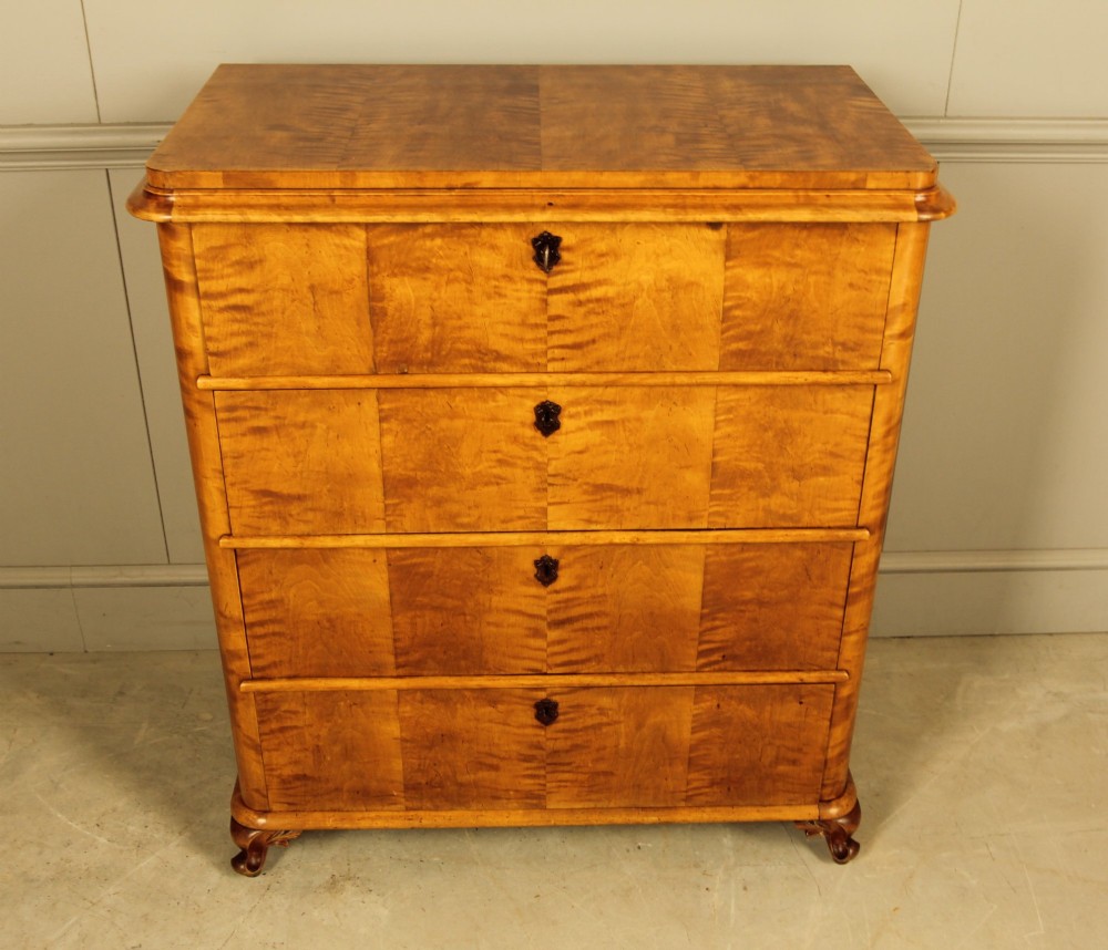A 19th-century Swedish chest of drawers crafted from flame birch veneer with four horizontal drawers, central dark escutcheons, and short carved bracket feet. View II