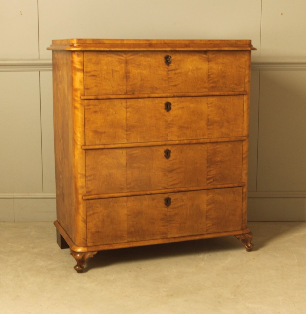 A 19th-century Swedish chest of drawers crafted from flame birch veneer with four horizontal drawers, central dark escutcheons, and short carved bracket feet. View III